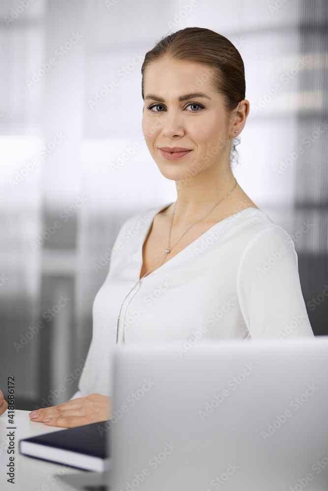 Businesswoman sitting and looking at camera in office. Business headshot Businesswoman sitting and looking at camera in office. Business headshot