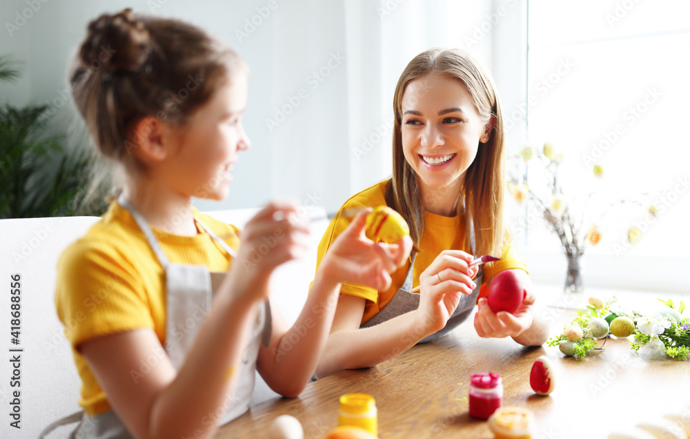 Delighted woman and girl painting Easter eggs together Delighted woman and girl painting Easter eggs together
