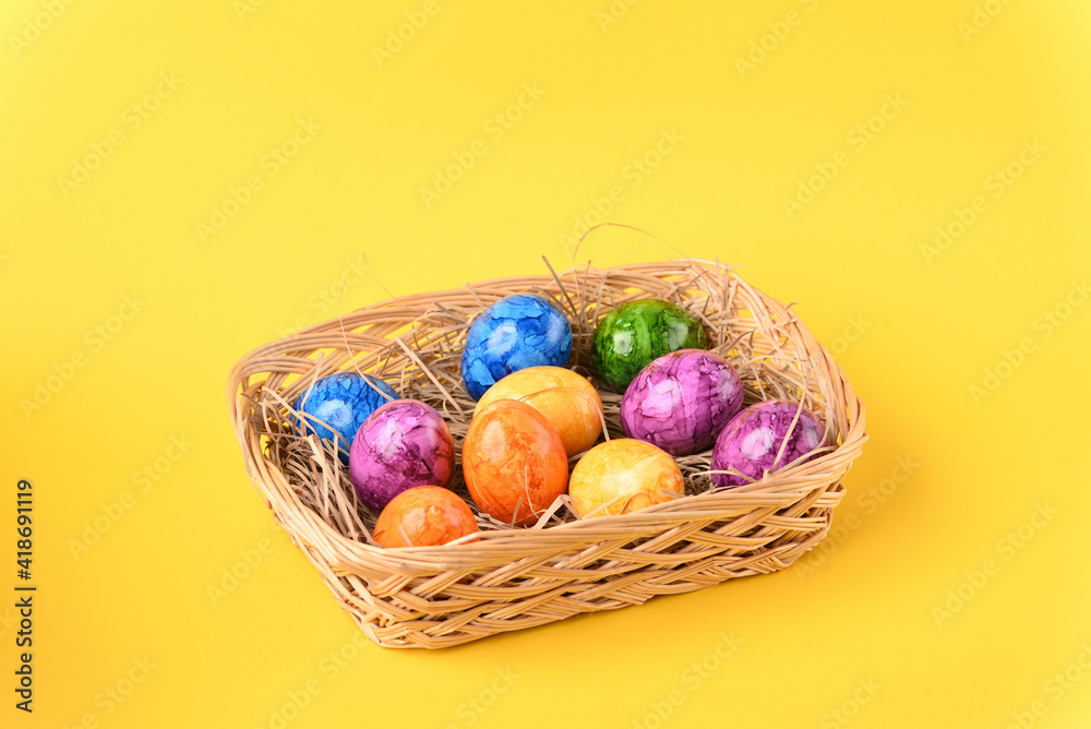 Colorful easter eggs in the basket on the yellow background. Colorful easter eggs in the basket on the yellow background.