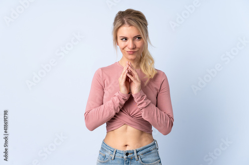 Blonde woman over isolated blue background scheming something