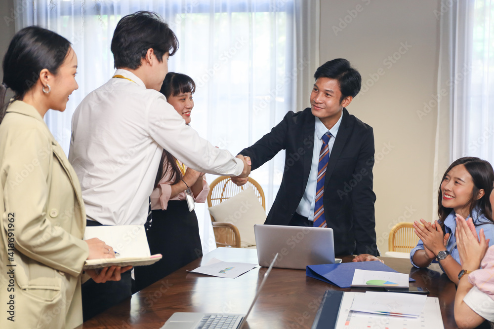 Young business people talking and discussing with coworker team while group meeting and handshake agreement in conference room Young business people talking and discussing with coworker team while group meeting and handshake agreement in conference room