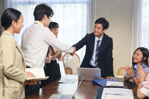 Young business people talking and discussing with coworker team while group meeting and handshake agreement in conference room