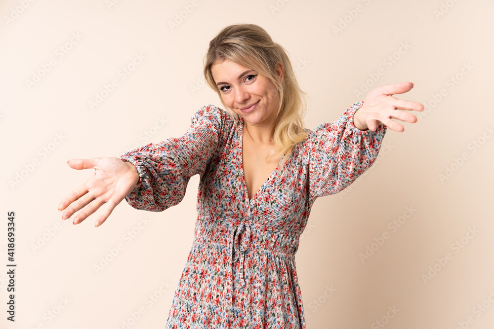 Blonde woman over isolated background presenting and inviting to come with hand Blonde woman over isolated background presenting and inviting to come with hand
