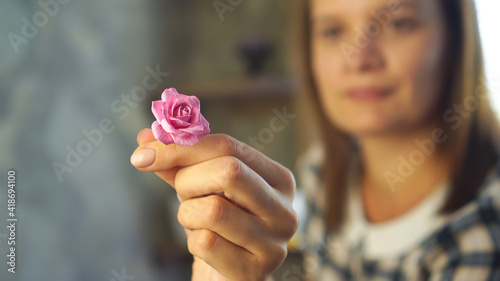 Handmade and business concept. Woman holds polymer clay flower.