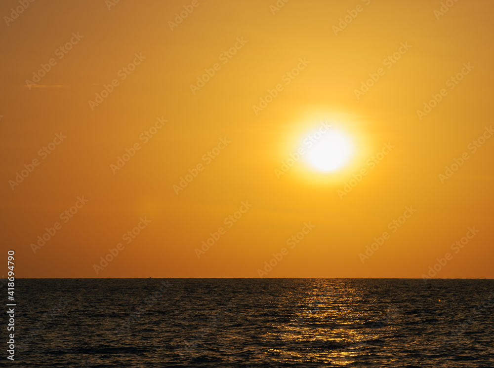 golden sunset or sunrise at the deep dark ocean. aerial view of sundown and up to the sea. yellow and orange colorful sky. romantic beautiful sky in the spring season. heavenly sky. new beginning