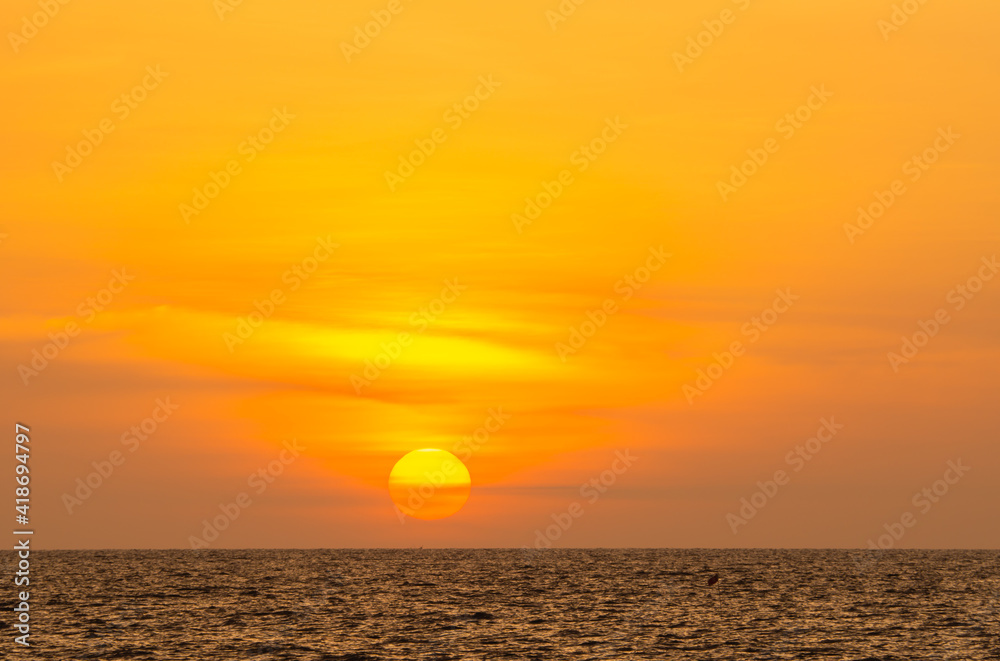 golden sunset or sunrise at the deep dark ocean. aerial view of sundown and up to the sea. yellow and orange colorful sky. romantic beautiful sky in the spring season. heavenly sky. new beginning