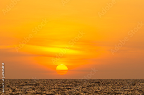golden sunset or sunrise at the deep dark ocean. aerial view of sundown and up to the sea. yellow and orange colorful sky. romantic beautiful sky in the spring season. heavenly sky. new beginning © phoomrat