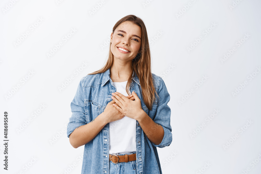 © Cookie Studio - Portrait of touched young woman feeling flattered, holding hands on heart and smiling white teeth, say thank you, appreciate help, being grateful for nice gesture, white background © Cookie Studio - Portrait of touched young woman feeling flattered, holding hands on heart and smiling white teeth, say thank you, appreciate help, being grateful for nice gesture, white background