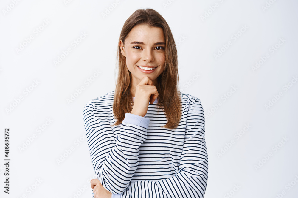 Very good. Thoughtful young woman nod in approval and smiling, looking determined and satisfied, standing pensive over white background Very good. Thoughtful young woman nod in approval and smiling, looking determined and satisfied, standing pensive over white background