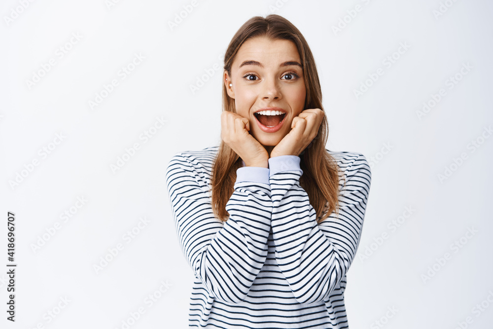Portrait of fascinted and amazed blond girl looking at camera fascinated, checking out something cool, seeing interesting thing, standing over white background Portrait of fascinted and amazed blond girl looking at camera fascinated, checking out something cool, seeing interesting thing, standing over white background