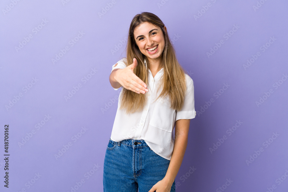 Young woman over isolated purple background shaking hands for closing a good deal Young woman over isolated purple background shaking hands for closing a good deal