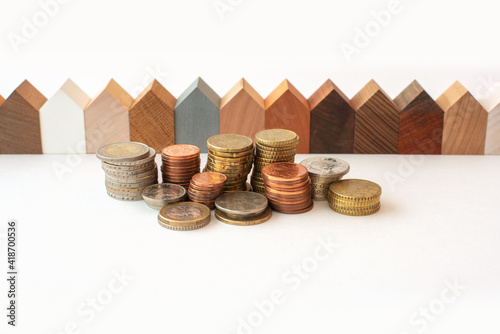homebuying or House purchase concept. Coins and wooden models of houses represent financial growth, real estate financing and investing in real estate. photo