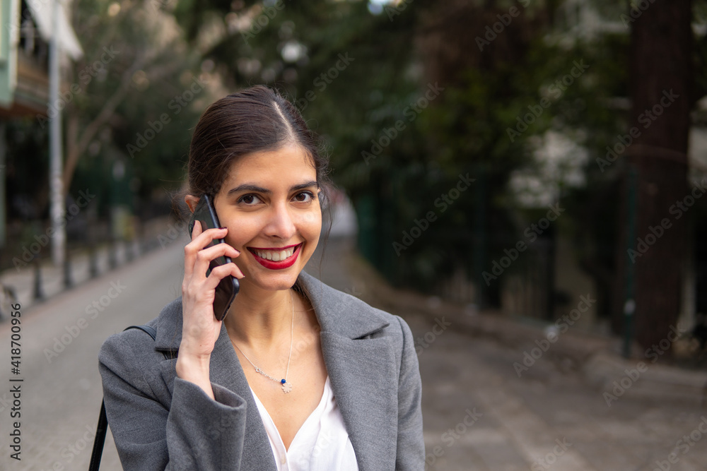 Cute businesswoman talking on the mobile phone with a nice smile and red lipstick Cute businesswoman talking on the mobile phone with a nice smile and red lipstick
