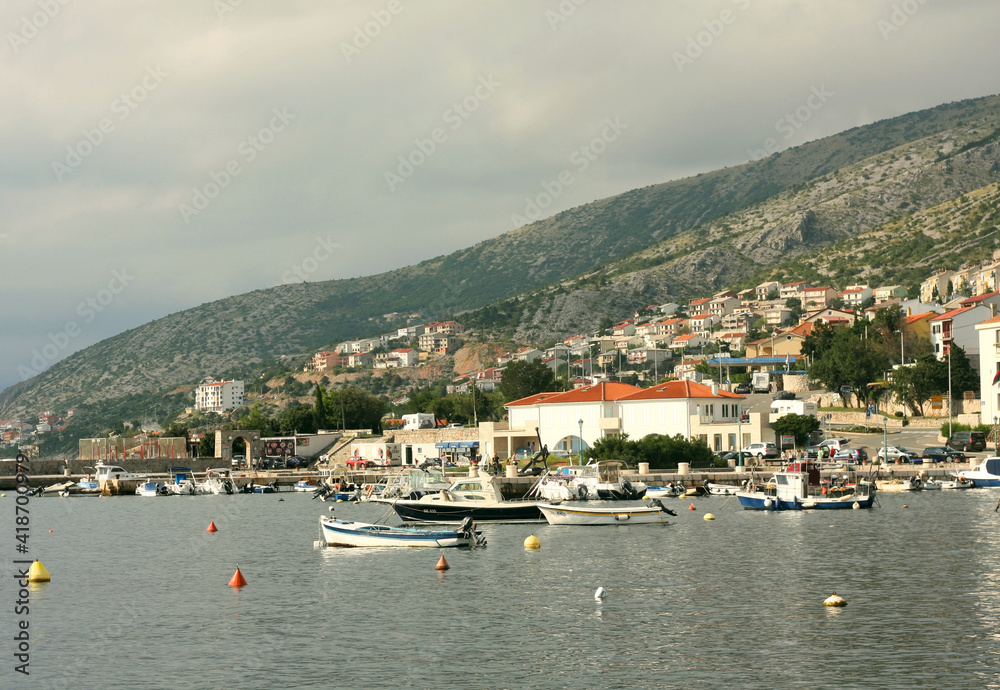 Port of Senj, Croatia. View of the port on the Adriatic Sea in Senj. Moored boats. In the background, the mountain above the town of Senj 