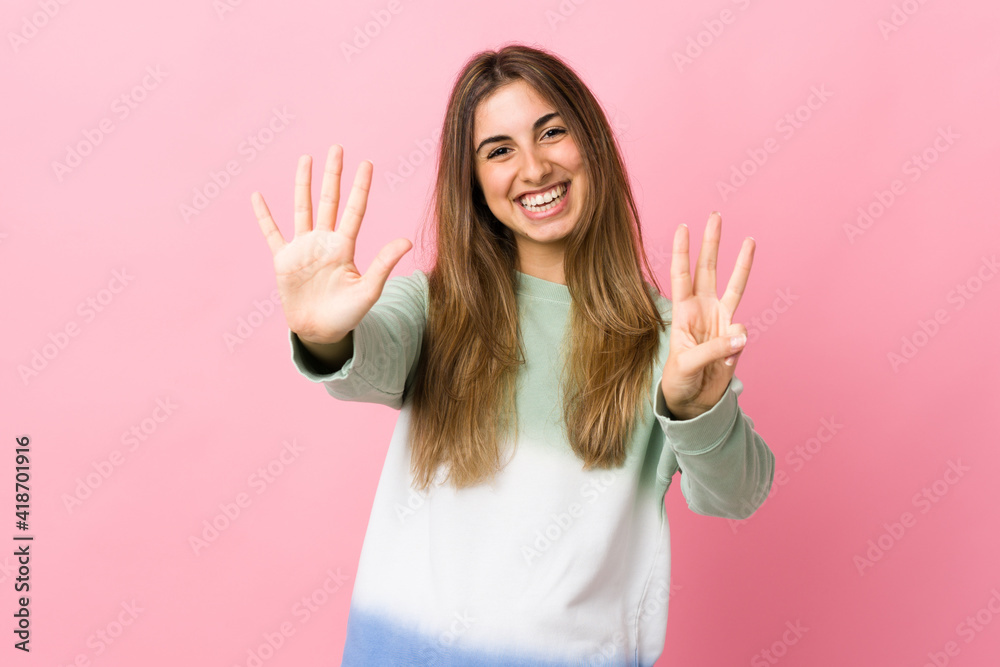 Young woman over isolated pink background counting eight with fingers Young woman over isolated pink background counting eight with fingers