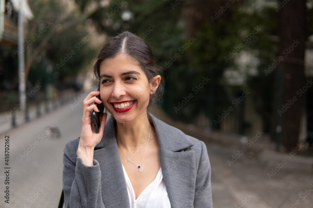 Arabic businesswoman talking on the mobile phone with a beautiful smile and red lipstick Arabic businesswoman talking on the mobile phone with a beautiful smile and red lipstick