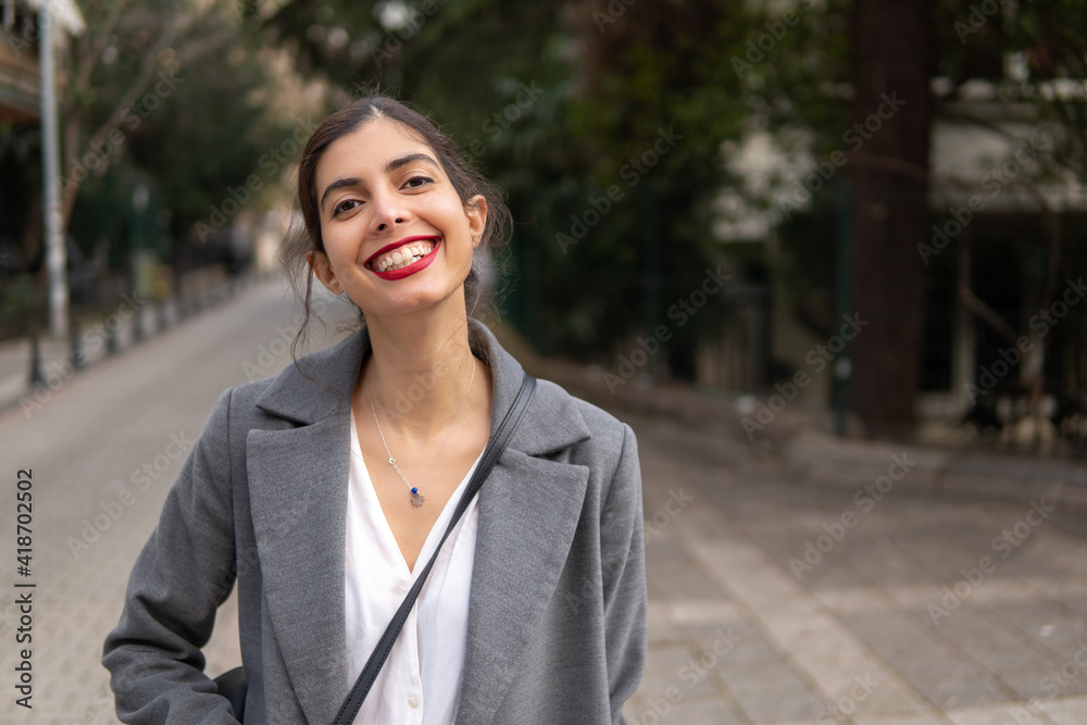 Happy Arabic businesswoman with big smile and red lipstick standing on the street Happy Arabic businesswoman with big smile and red lipstick standing on the street