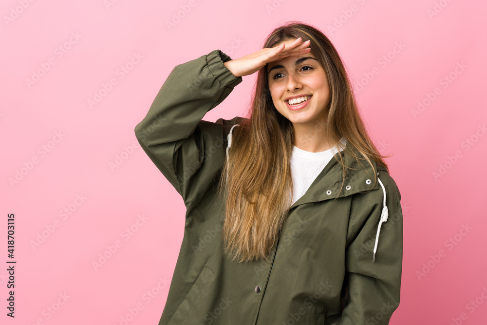 Young woman over isolated pink background looking far away with hand to look something Young woman over isolated pink background looking far away with hand to look something