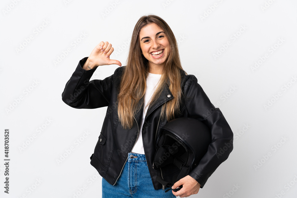 Young Woman holding a motorcycle helmet over isolated white background proud and self-satisfied Young Woman holding a motorcycle helmet over isolated white background proud and self-satisfied
