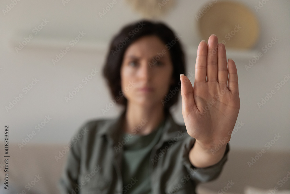 I said stop it. Blurred portrait of young lady looking at camera extending hand forward saying no enough to abuse family violence abortion. Focus on female palm close up raised in prohibiting gesture I said stop it. Blurred portrait of young lady looking at camera extending hand forward saying no enough to abuse family violence abortion. Focus on female palm close up raised in prohibiting gesture