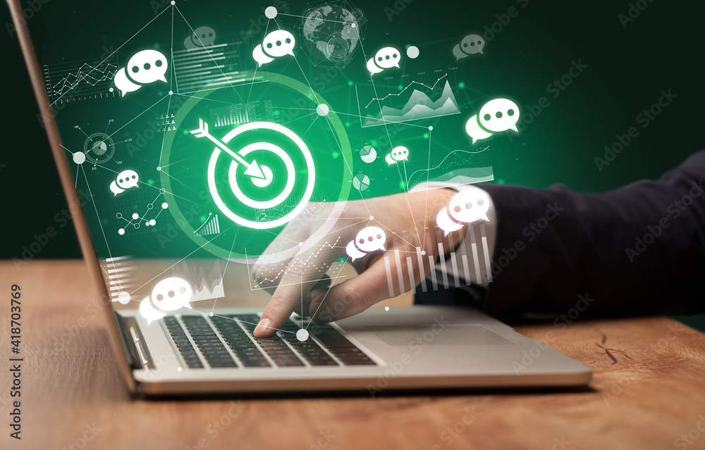Business hand working on laptop with target icons coming out from the screen, successful business concept Business hand working on laptop with target icons coming out from the screen, successful business concept