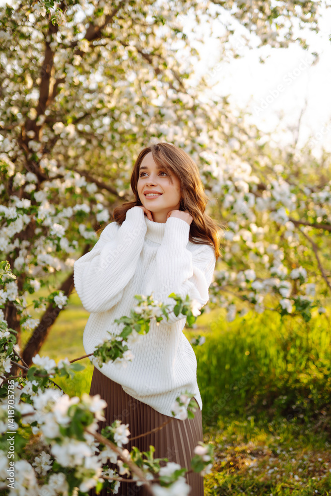 Young woman enjoying scent in blooming spring garden. The concept of youth, love, fashion and lifestyle. Young woman enjoying scent in blooming spring garden. The concept of youth, love, fashion and lifestyle.