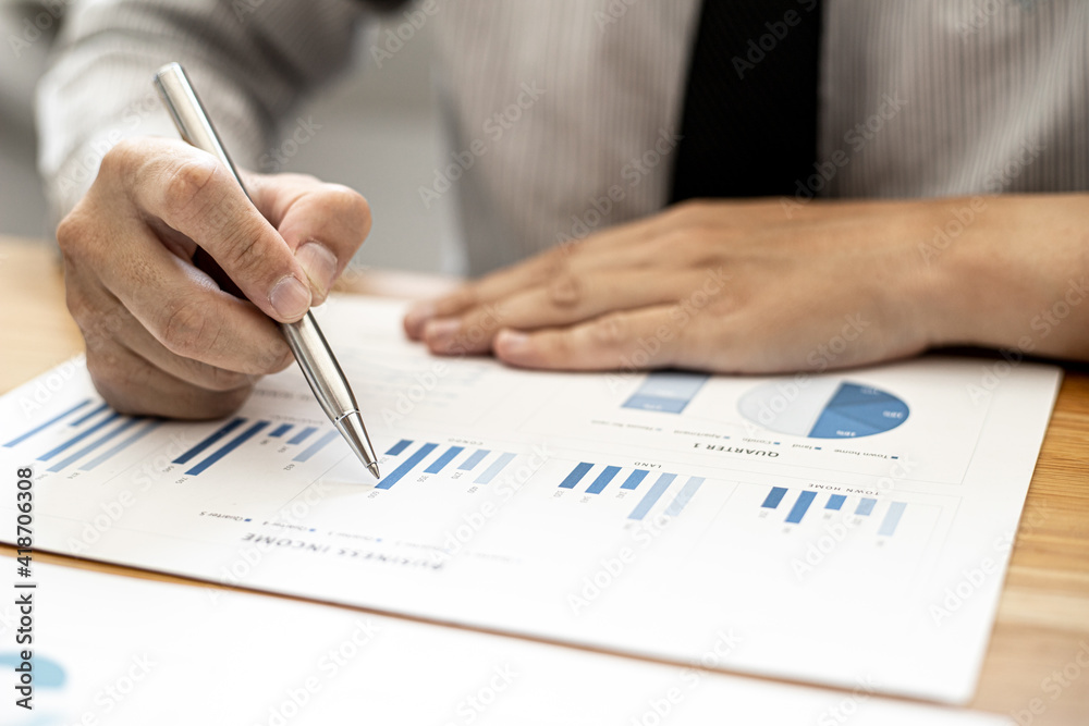 A businessman is analyzing the company's financial data from the documents provided by the Finance Department, he examines the data and analyzes and plans for more growth. Financial concept. A businessman is analyzing the company's financial data from the documents provided by the Finance Department, he examines the data and analyzes and plans for more growth. Financial concept.