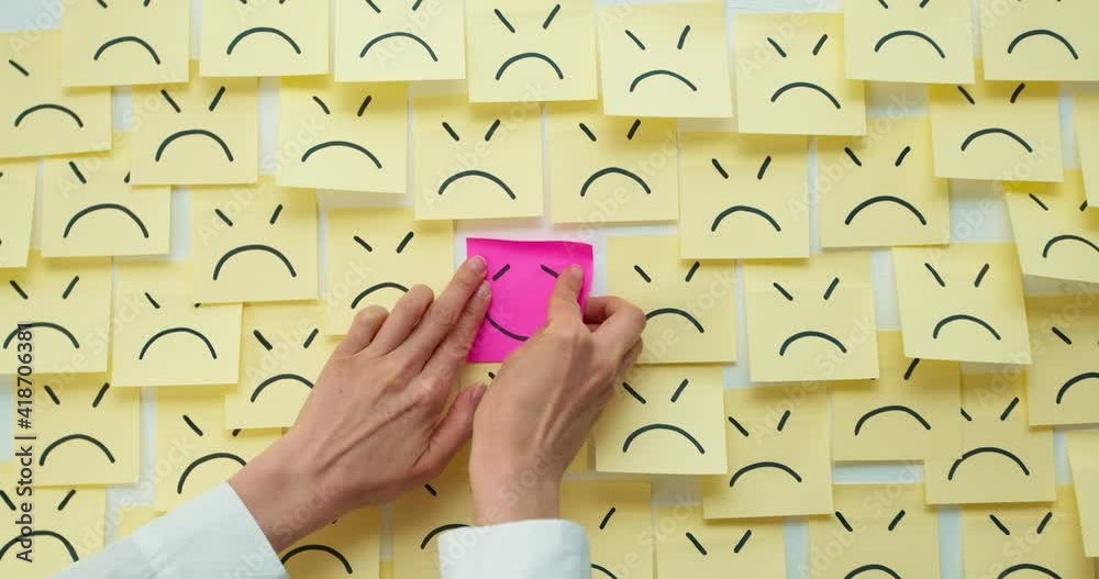 Business woman hands stick note smiling symbol on sad background. The concept of a successful solution to the problem. Positive idea or news.