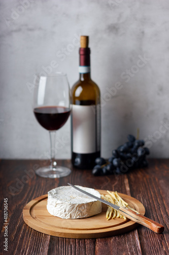 Red wine with cheese plate. Assorted cheeses Camembert and smoke cheese.