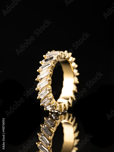 ring jewelry with glass colored stones with reflection on black background