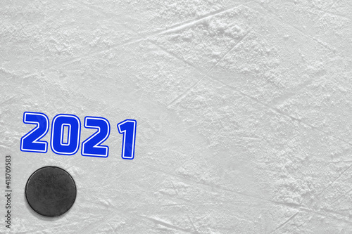 Fragment of an ice rink with a blue inscription and a hockey puck