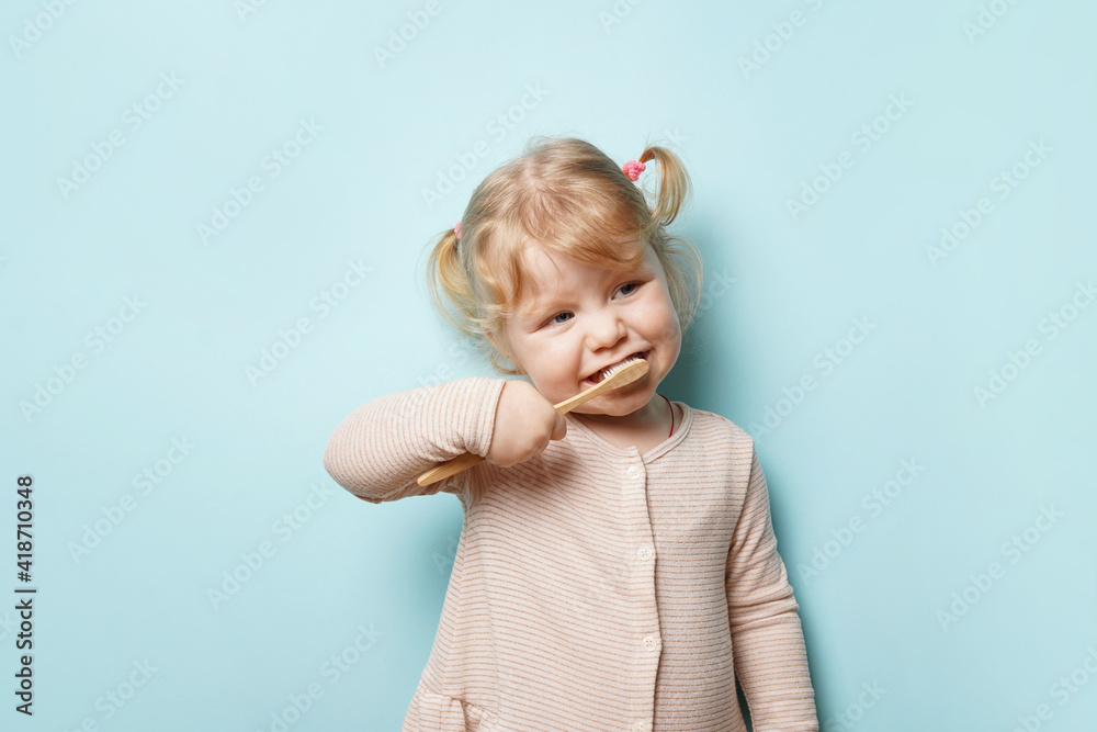 child girl brushing teeth on blue background. child girl brushing teeth on blue background.