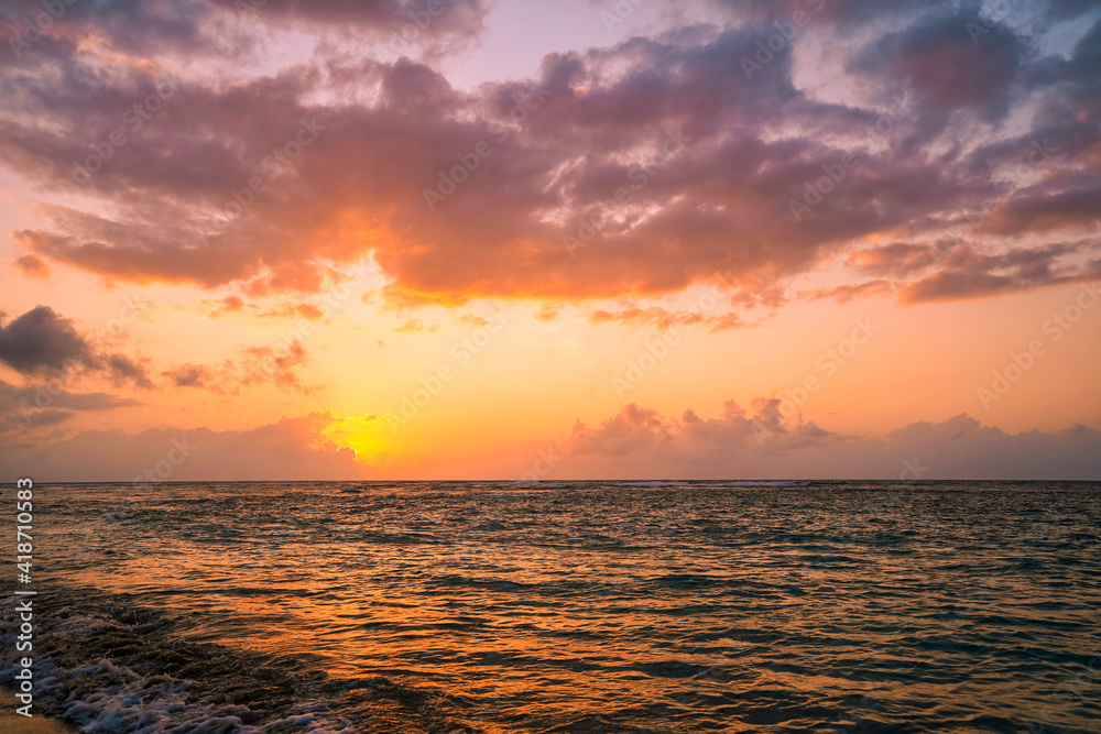 Obraz premium beautiful golden sunset on the beach over the sea with some dreamy clouds