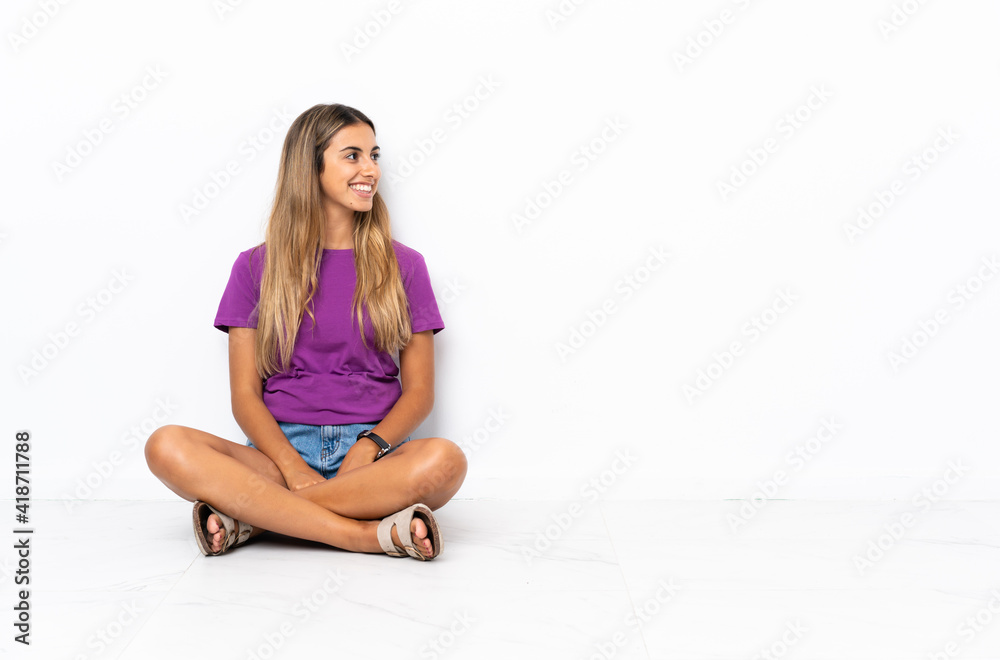 Young hispanic woman sitting on the floor looking side Young hispanic woman sitting on the floor looking side