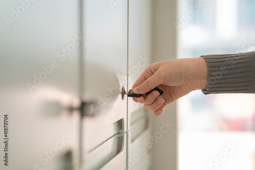 Woman hands opening a lock with a key.