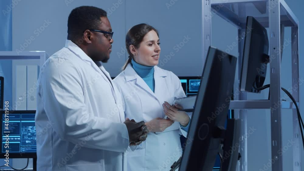 Diverse team of microelectronic engineers discuss current developments in a science lab. Workplace of microprocessor designers. The concept of innovations and inventions.