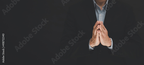 businessman hand praying and worship to GOD Using hands to pray in religious beliefs and worship christian in the church or in general locations in vintage black tone or copy space.