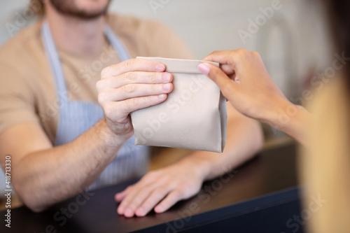 Male and female hands holding paper bag