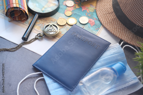 protective mask, map and blue color passport on table 