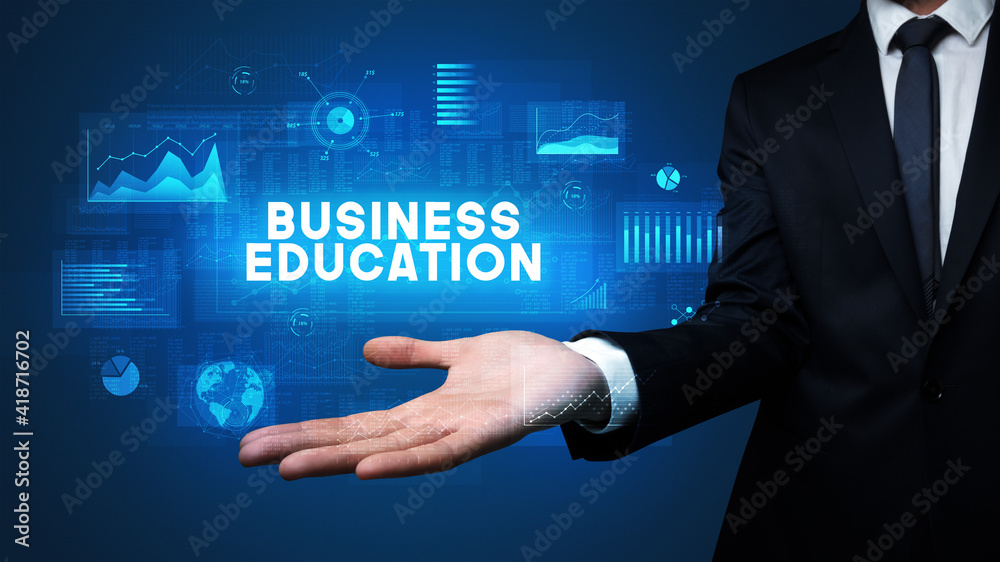 Hand of Businessman holding BUSINESS EDUCATION inscription, business success concept Hand of Businessman holding BUSINESS EDUCATION inscription, business success concept