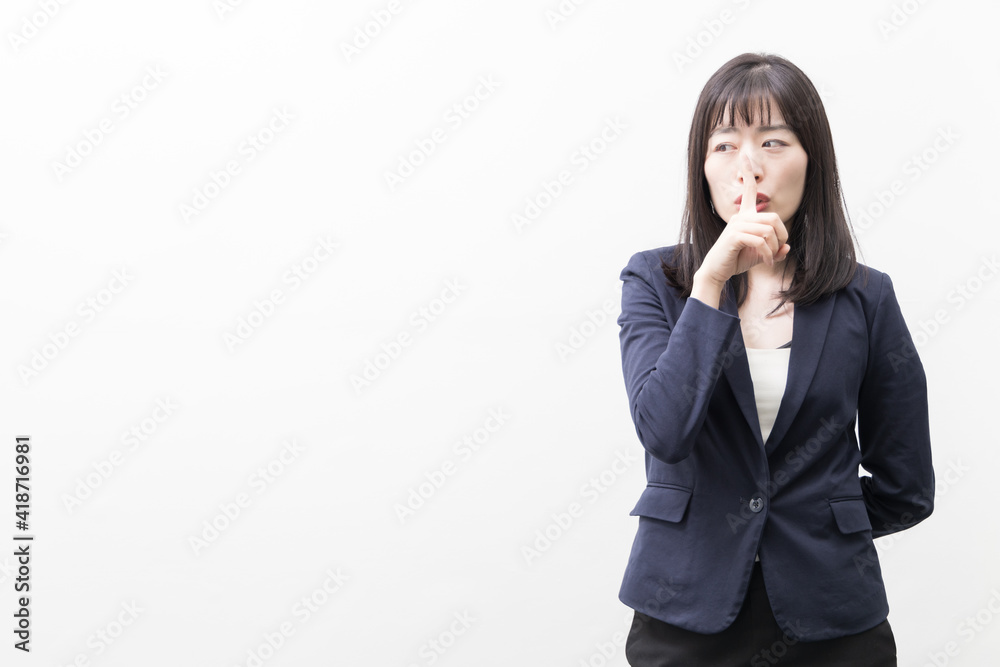 Woman raises her index finger in front of her mouth (gesture) Woman raises her index finger in front of her mouth (gesture)