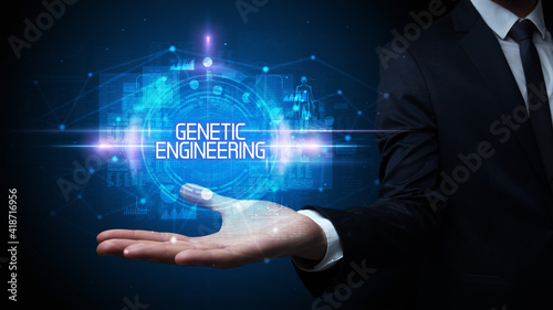 Man hand holding GENETIC ENGINEERING inscription, technology concept