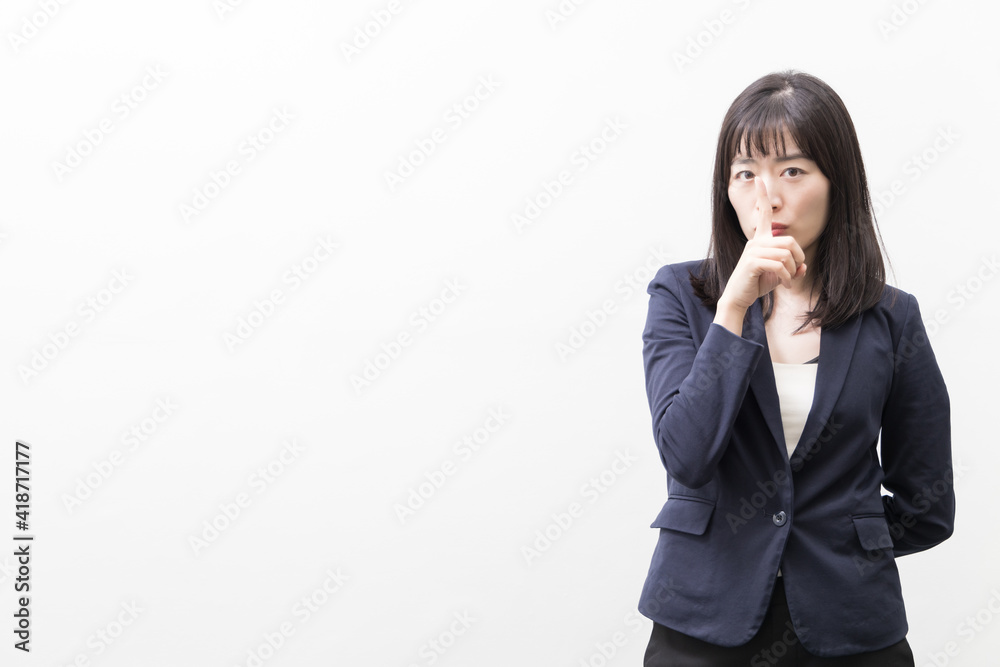 Woman raises her index finger in front of her mouth (gesture) Woman raises her index finger in front of her mouth (gesture)