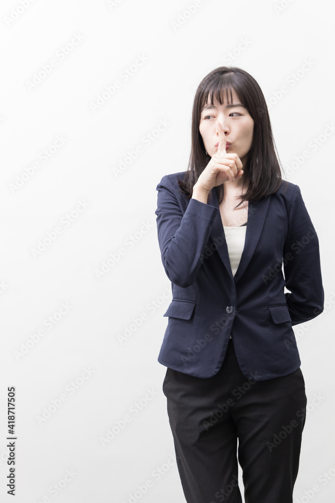 Woman raises her index finger in front of her mouth (gesture) Woman raises her index finger in front of her mouth (gesture)