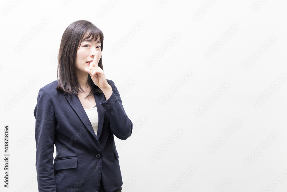 Woman raises her index finger in front of her mouth (gesture) Woman raises her index finger in front of her mouth (gesture)