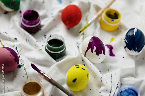 Easter background with colorful eggs and paints on light, DIY, top view