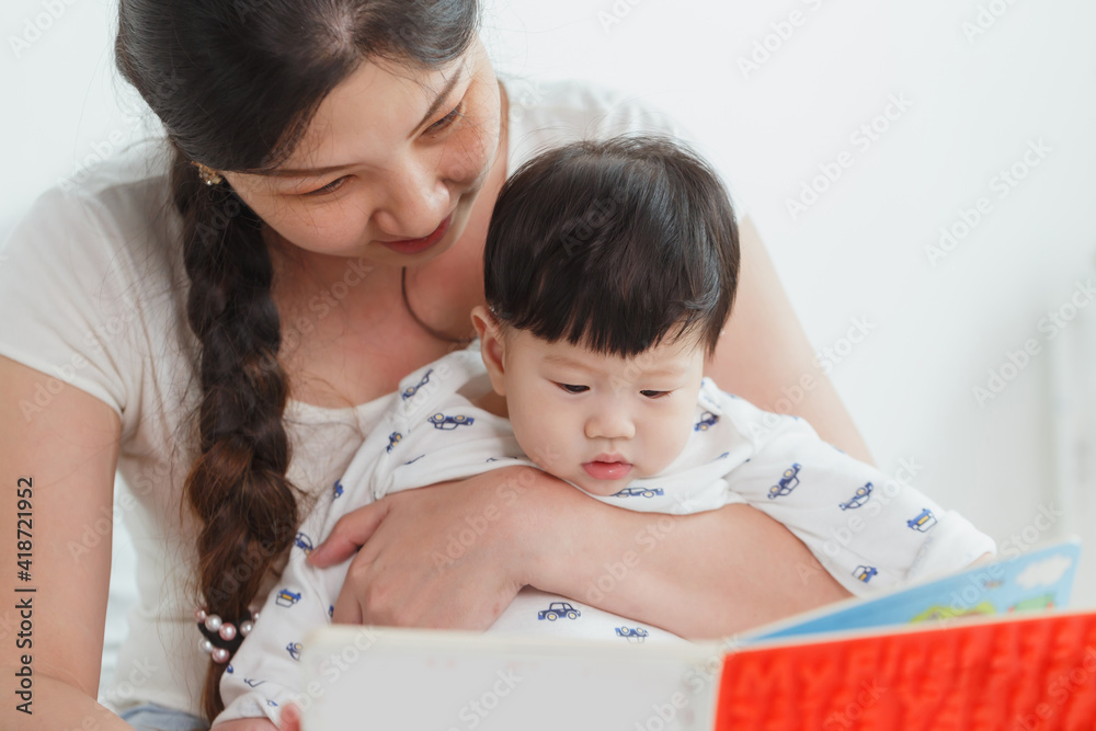 Young happy Asian woman reading book with the little baby boy. Development education concept Young happy Asian woman reading book with the little baby boy. Development education concept