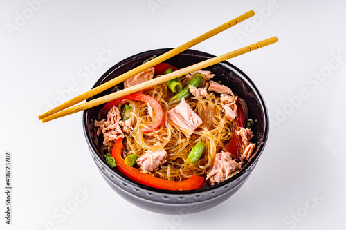delicious glass noodles with tuna and vegetables on a white acrylic background