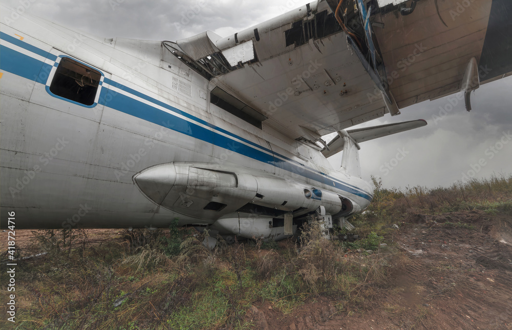 An abandoned old Soviet cargo plane lying on the ground in cloudy weather An abandoned old Soviet cargo plane lying on the ground in cloudy weather