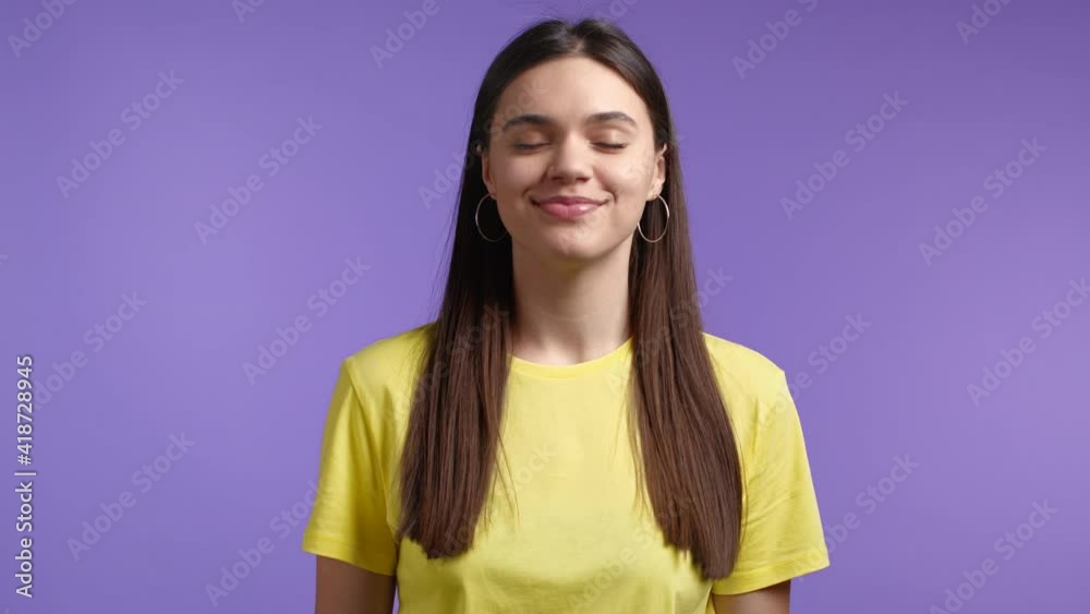 Cheerful woman showing yes sign, nods her head approvingly. Positive smiling girl, emotions, body language concept. Violet studio background. Cheerful woman showing yes sign, nods her head approvingly. Positive smiling girl, emotions, body language concept. Violet studio background.